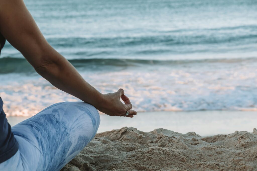 Man practicing Surya Namaskar yoga sequence outdoors at sunrise